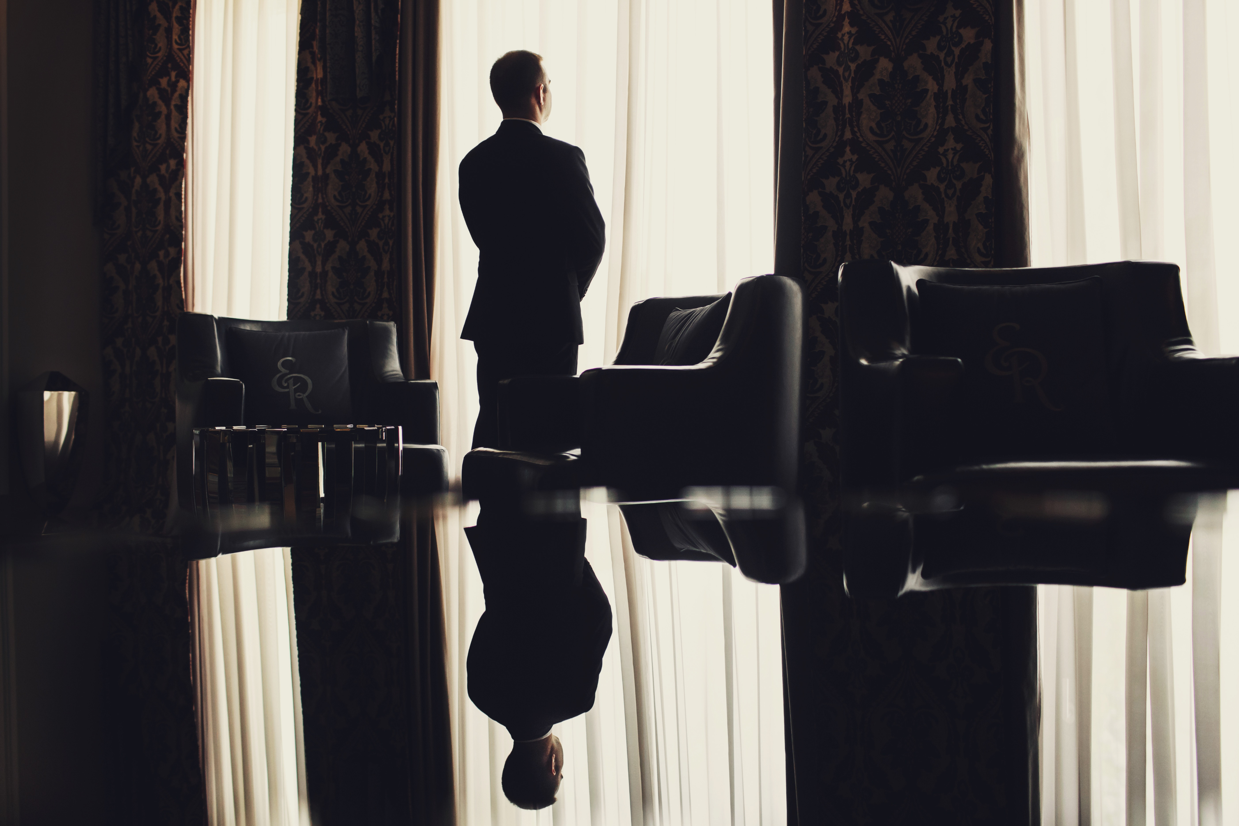 Photo of a man giving a talk on stage with blue curtains behind him.